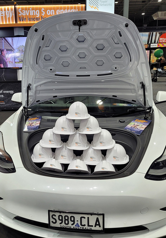 A display of some items at the SA Power Networks stand at the Royal Adelaide Show includes toy hard hats and a Tesla electric vehicle.